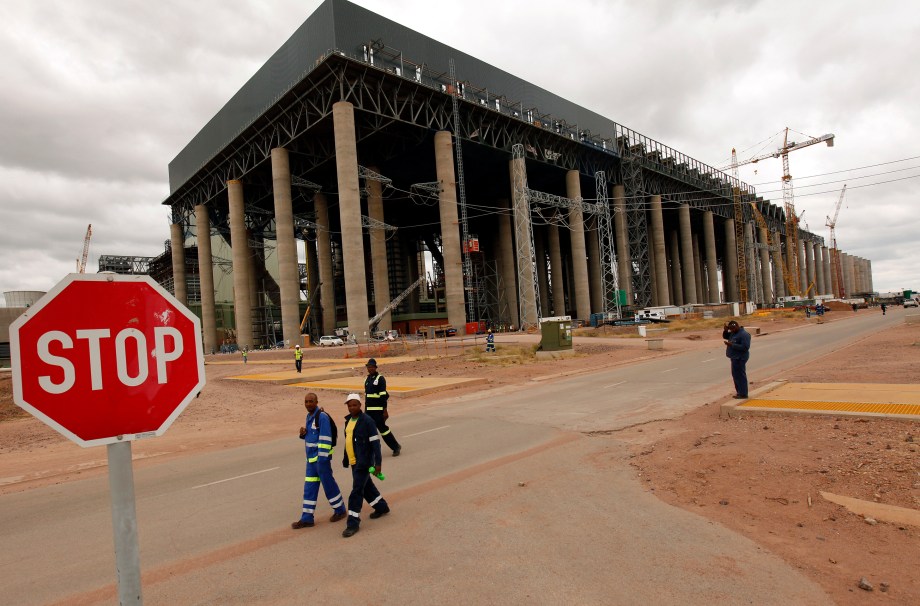 Workers walk past the construction site of Medupi power station in Lephalele